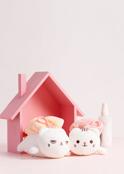 two cat plushies in pink toy house