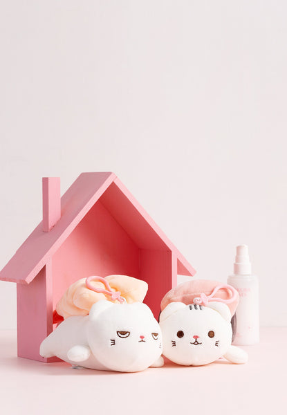 two cat plushies in pink toy house