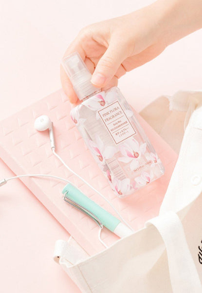 person placing perfume bottle into We Bare Bears bag along with headphones, notebook and utensils