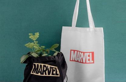marvel tote bags: black marvel tote bag has plant inside, white marvel tote bag is behind it 