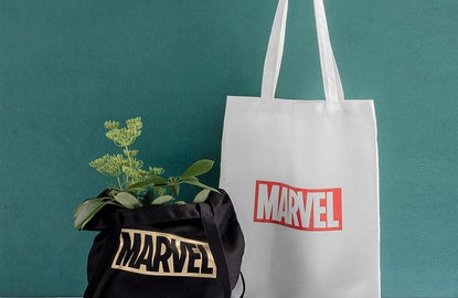 marvel tote bags: black marvel tote bag has plant inside, white marvel tote bag is behind it
