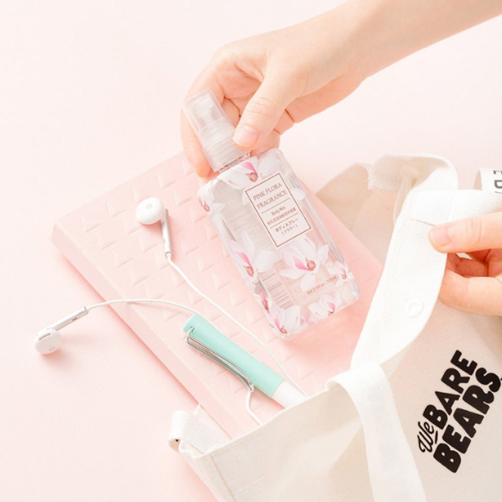 person placing perfume bottle into We Bare Bears bag along with headphones, notebook and utensils