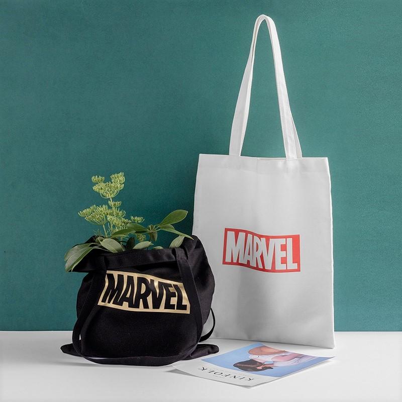 marvel tote bags: black marvel tote bag has plant inside, white marvel tote bag is behind it 